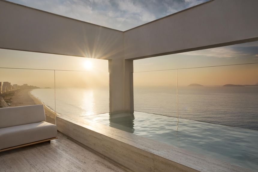 atardecer en la piscina moderna frente al mar de hotel Janeiro
