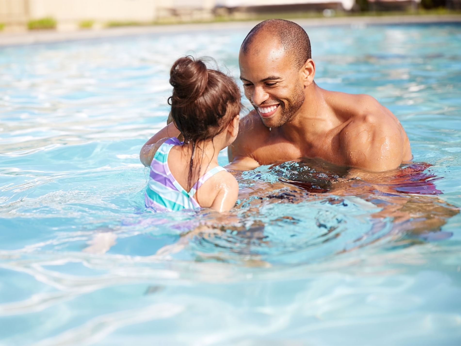 a father swims with his daughter