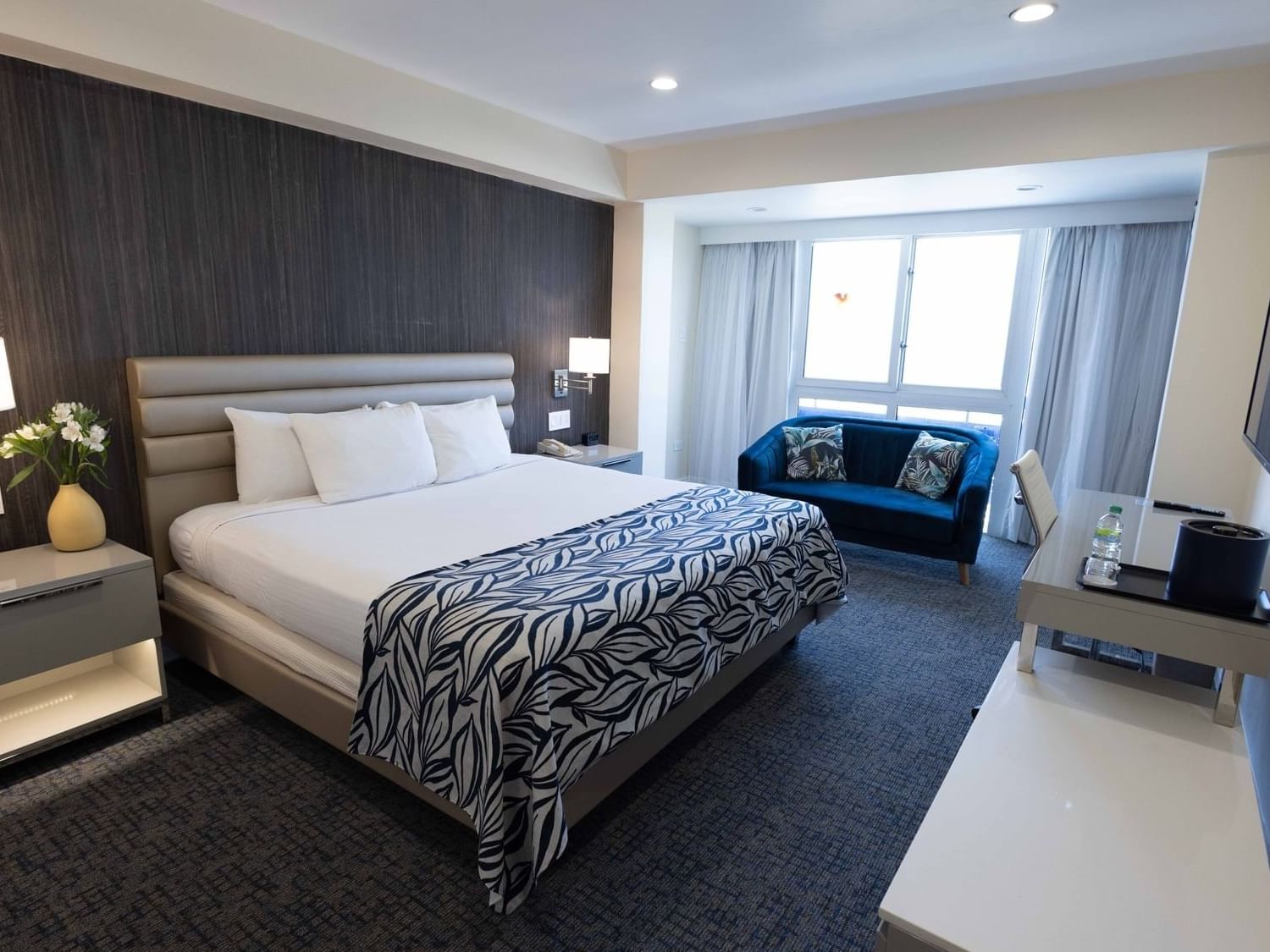 King bed with sofa in Royal Deluxe Room at Jamaica Pegasus Hotel, featuring elegant rooms at Pegasus Hotel Kingston Jamaica