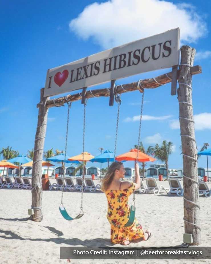 Woman sitting on swing at beach in Lexis Hibiscus