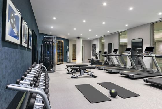fitness center with exercise equipment, mats and treadmills