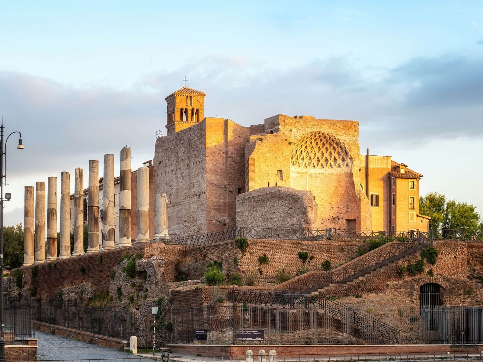 Domus Aurea featuring tall columns, brick structures, and a bell tower near The Glam Hotel