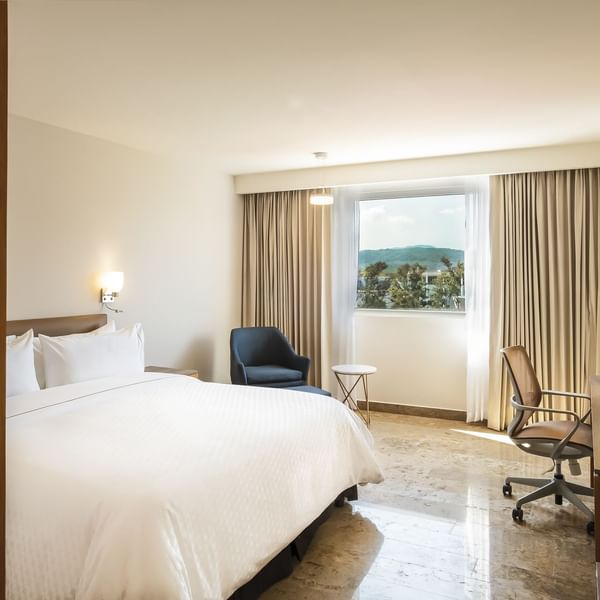 King bed in Superior Room with working desk at Fiesta Inn