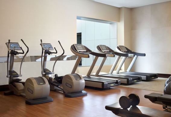 Exercise machines in the Gym with wooden floors at Po Hotel Semarang