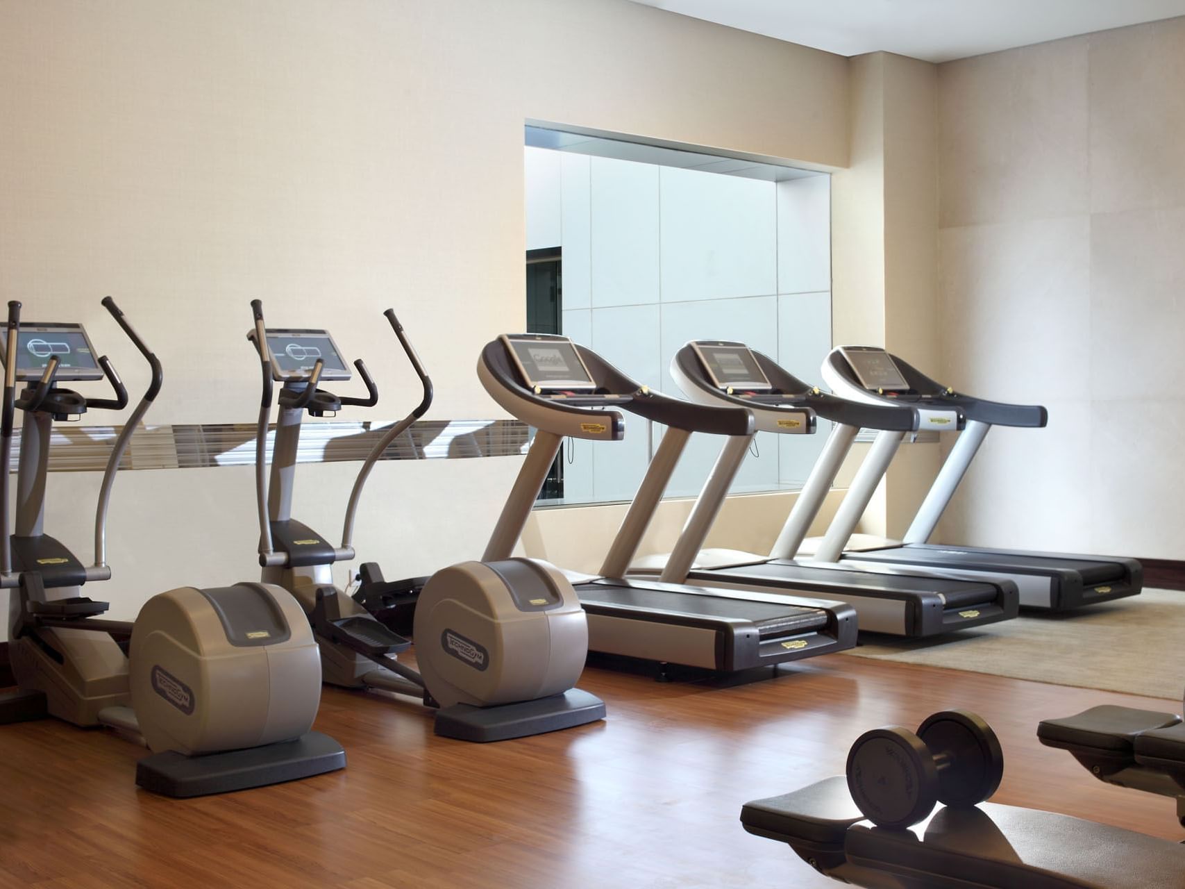 Exercise machines in the Gym with wooden floors at Po Hotel Semarang