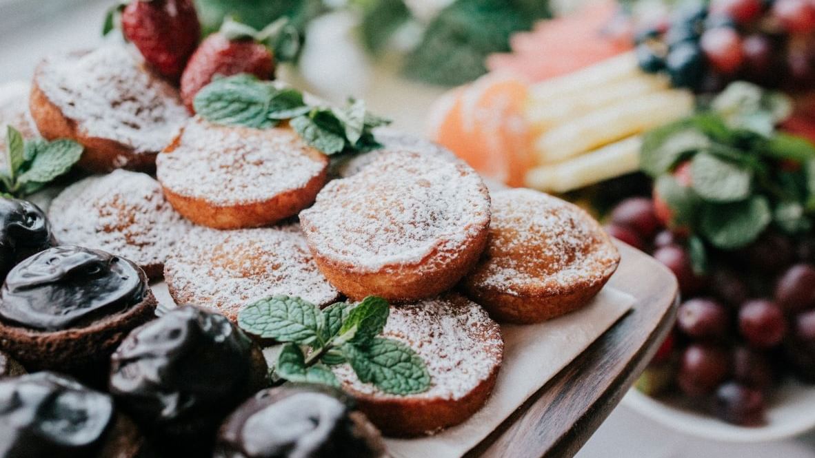 Assorted desserts with berries and mint on a wooden tray at Mercure Charlestown.