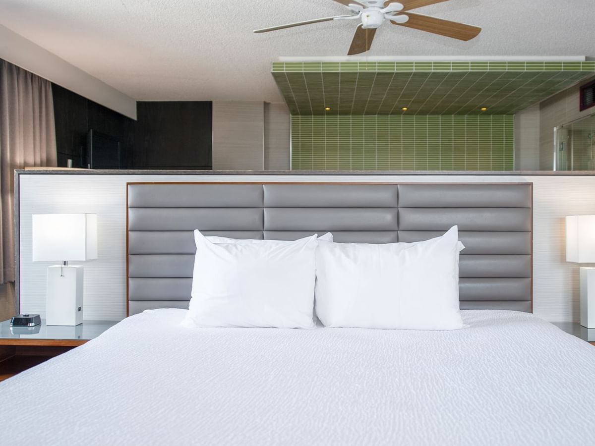 Large king bed, nightstands, lamps, and ceiling fan.