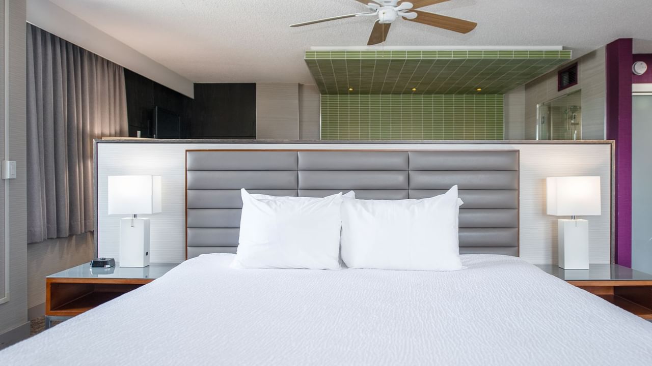 Large king bed, nightstands, lamps, and ceiling fan.