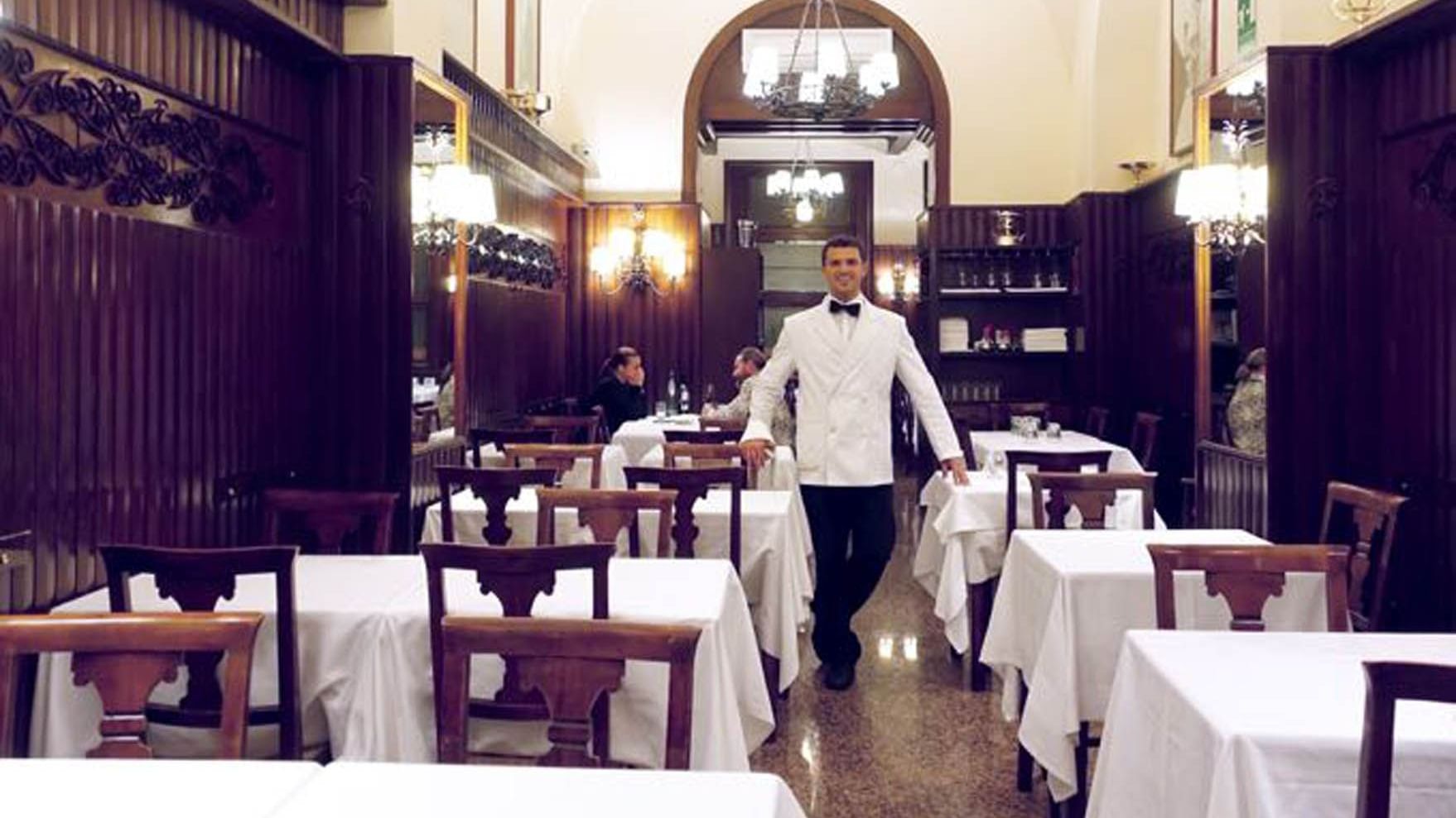 A waiter standing middle of the dining area in Ristorante Nino near Rome Luxury Suites