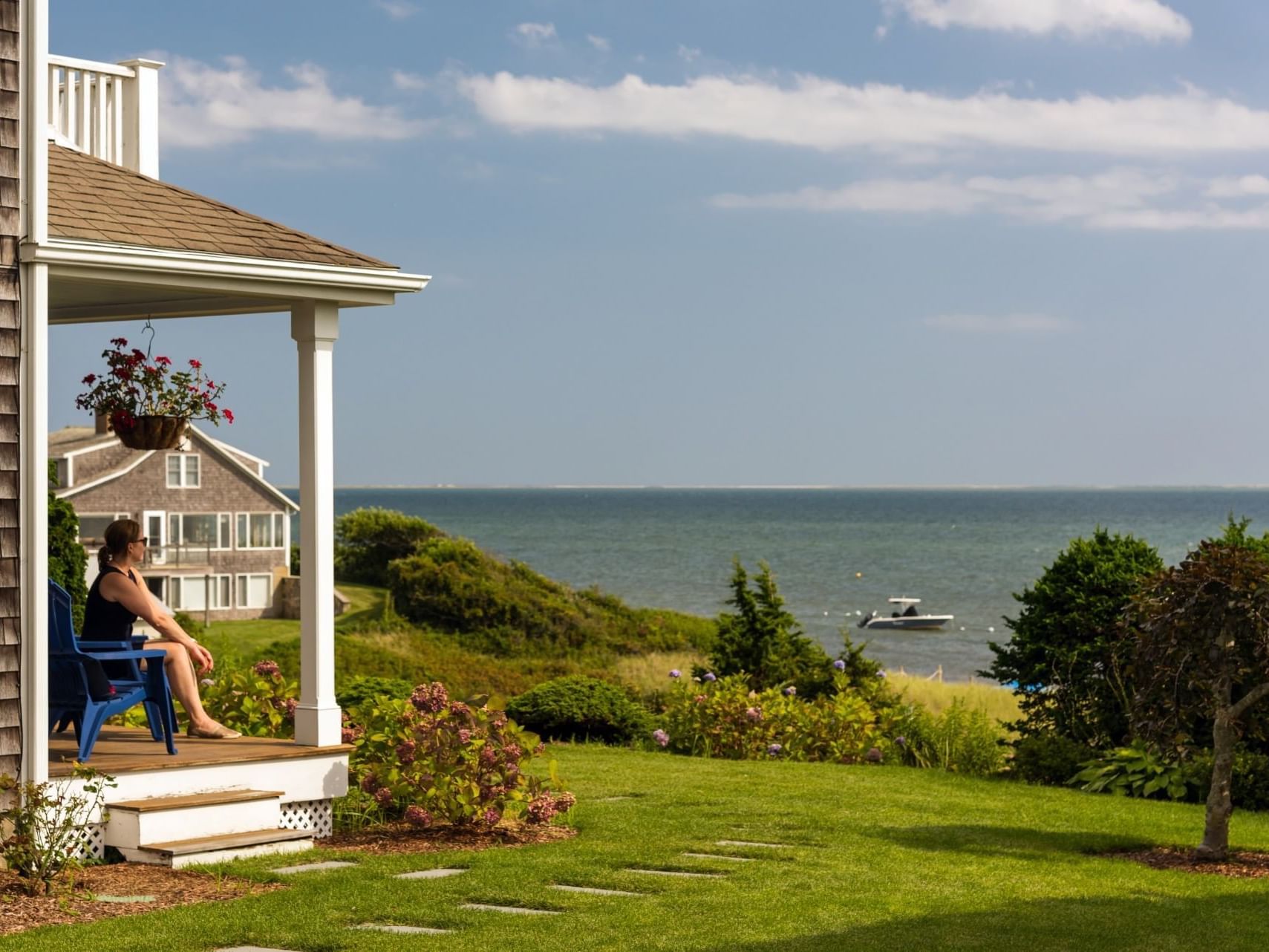 Lady overlooking the sea on the balcony lounge in Eventide 4-bedroom House at Chatham Tides Resort