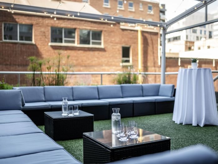 Blue sofa sections surrounding geometric tables on a Lounge Bishop terrace at Warwick Le Crystal Montreal