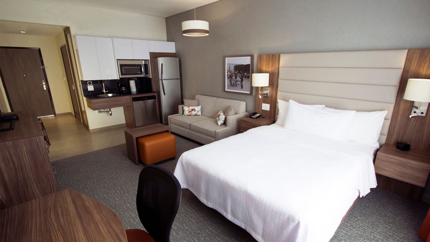 Bed and a couch in Suite Capacidades Diferentes at Fiesta Inn Suites Aeropuerto del Bajío Silao