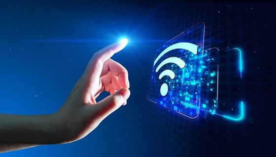 Hand by a glowing Wi-Fi icon under a digital blue light near Paramount Hotel Seattle