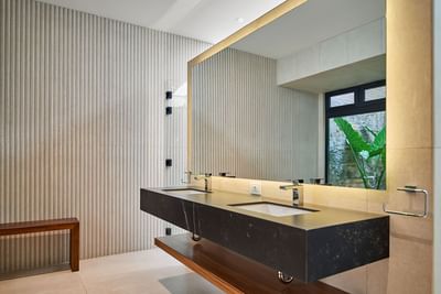 Casa Campanas bathroom with a black double vanity, a large mirror, and textured wall tiles at Singular Signature Residences