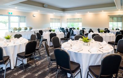 Black chairs around round tables in Montague at Rodd Brudenell River Resort, a premier place to stay in PEI