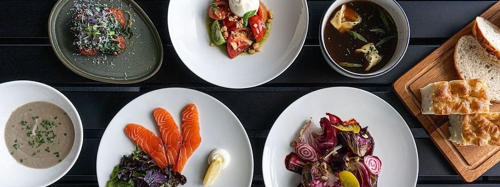 A table filled with elegantly plated dishes served in The Cellar Kitchen at Novotel Barossa Valley Resort