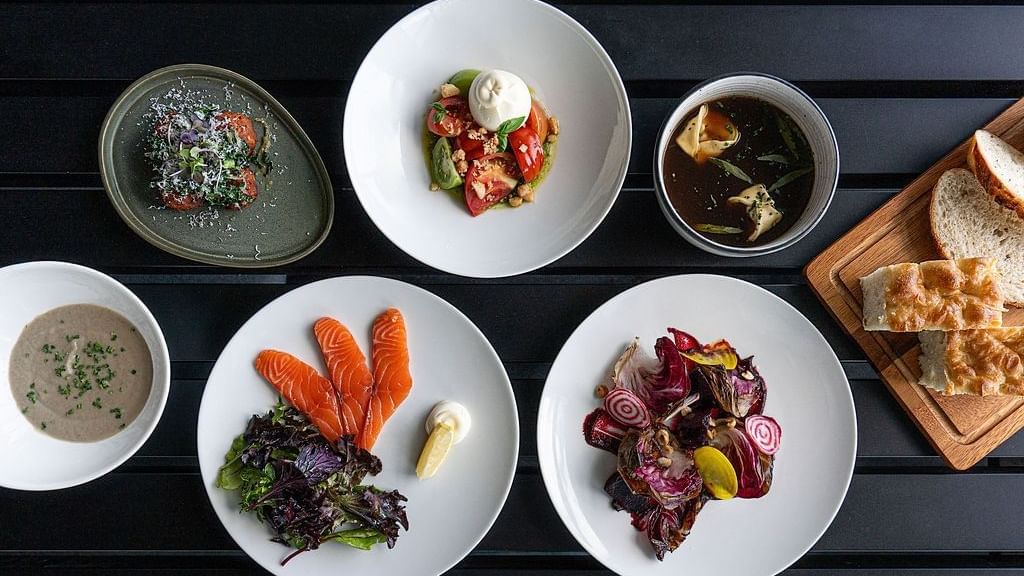 A table filled with elegantly plated dishes served in The Cellar Kitchen at Novotel Barossa Valley Resort