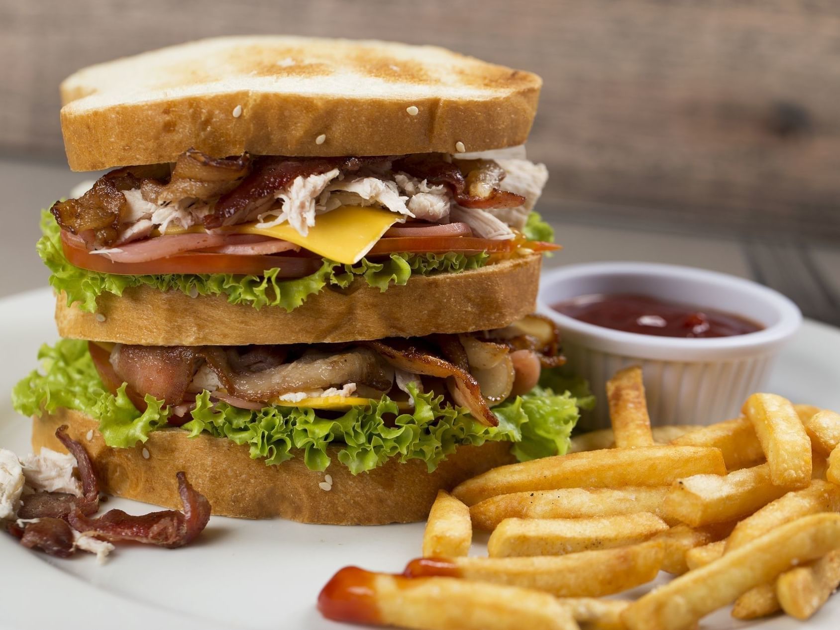 Club sandwich, potato chips, and dipping sauce in Xocomil Bar at Porta Hotel del Lago