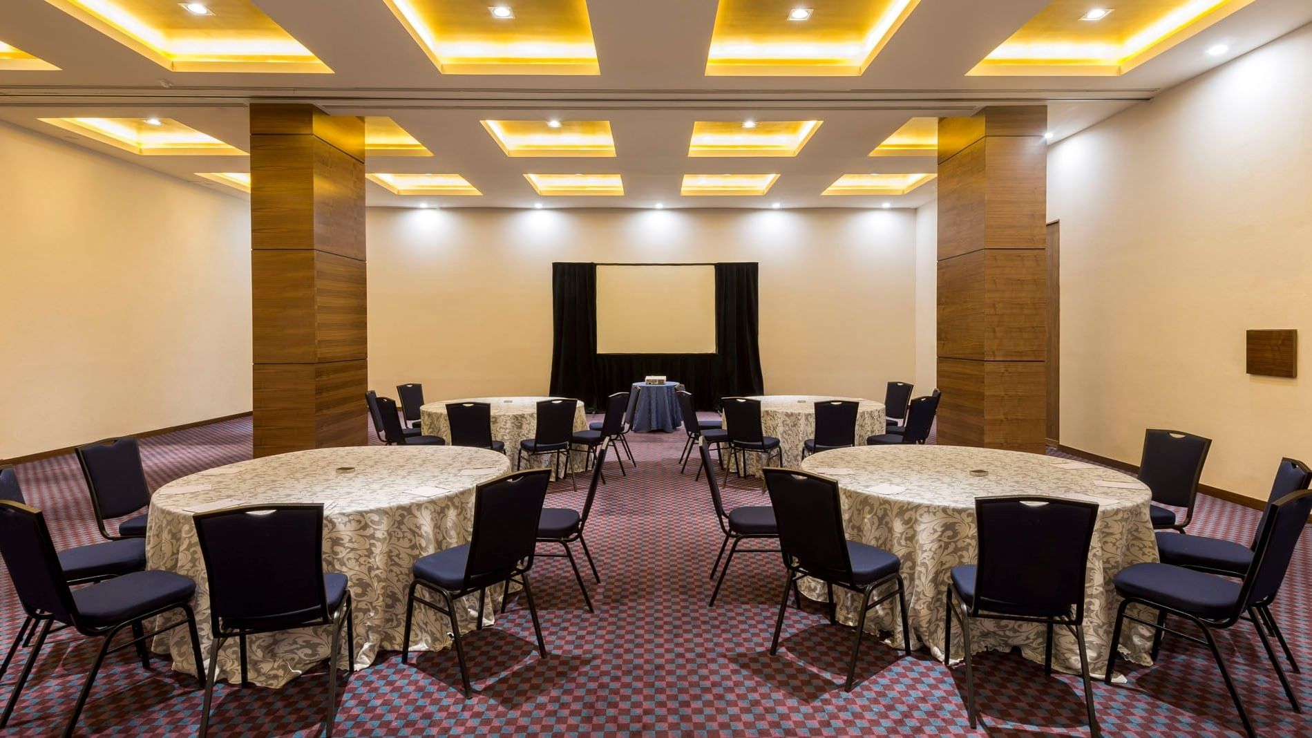 Spacious Sol conference room at Camino Real Pedregal Mexico, set up with round tables and navy blue chairs