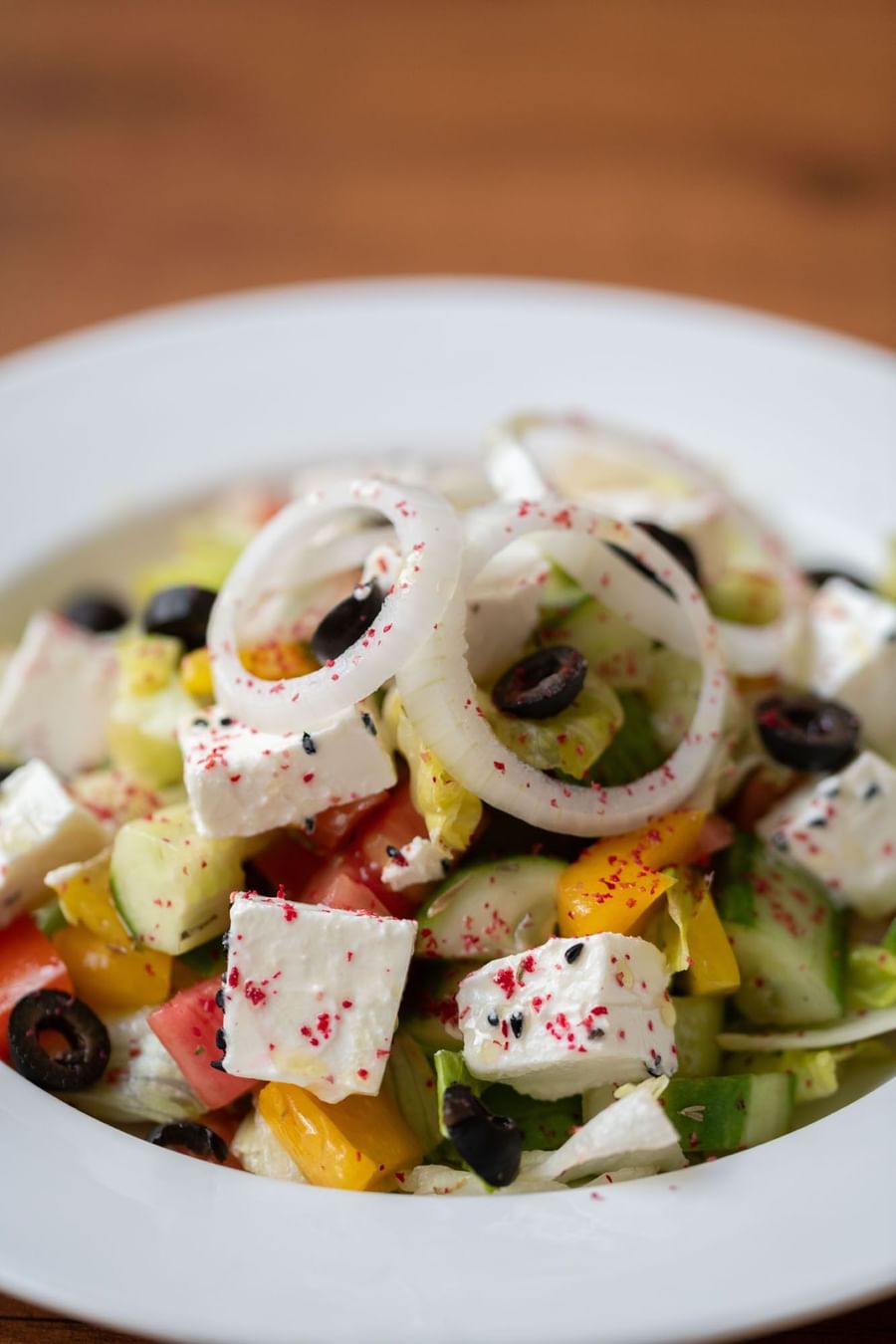 Close-up of a fresh salad featuring diced cucumber, onion rings, & feta cheese in Seasons Restaurant at Warwick Hotel Jeddah