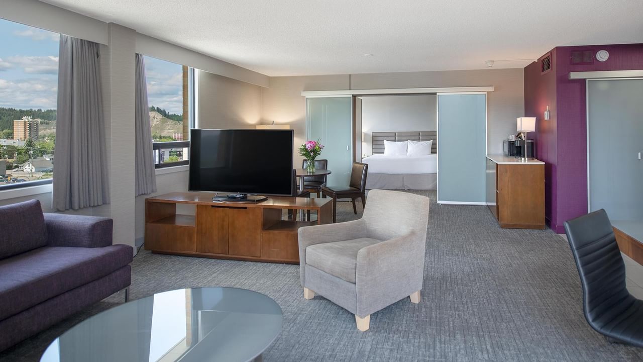 Spacious Coast Presidential King Suite with living area, flat-screen TV, and separate bedroom at Coast Prince George Hotel