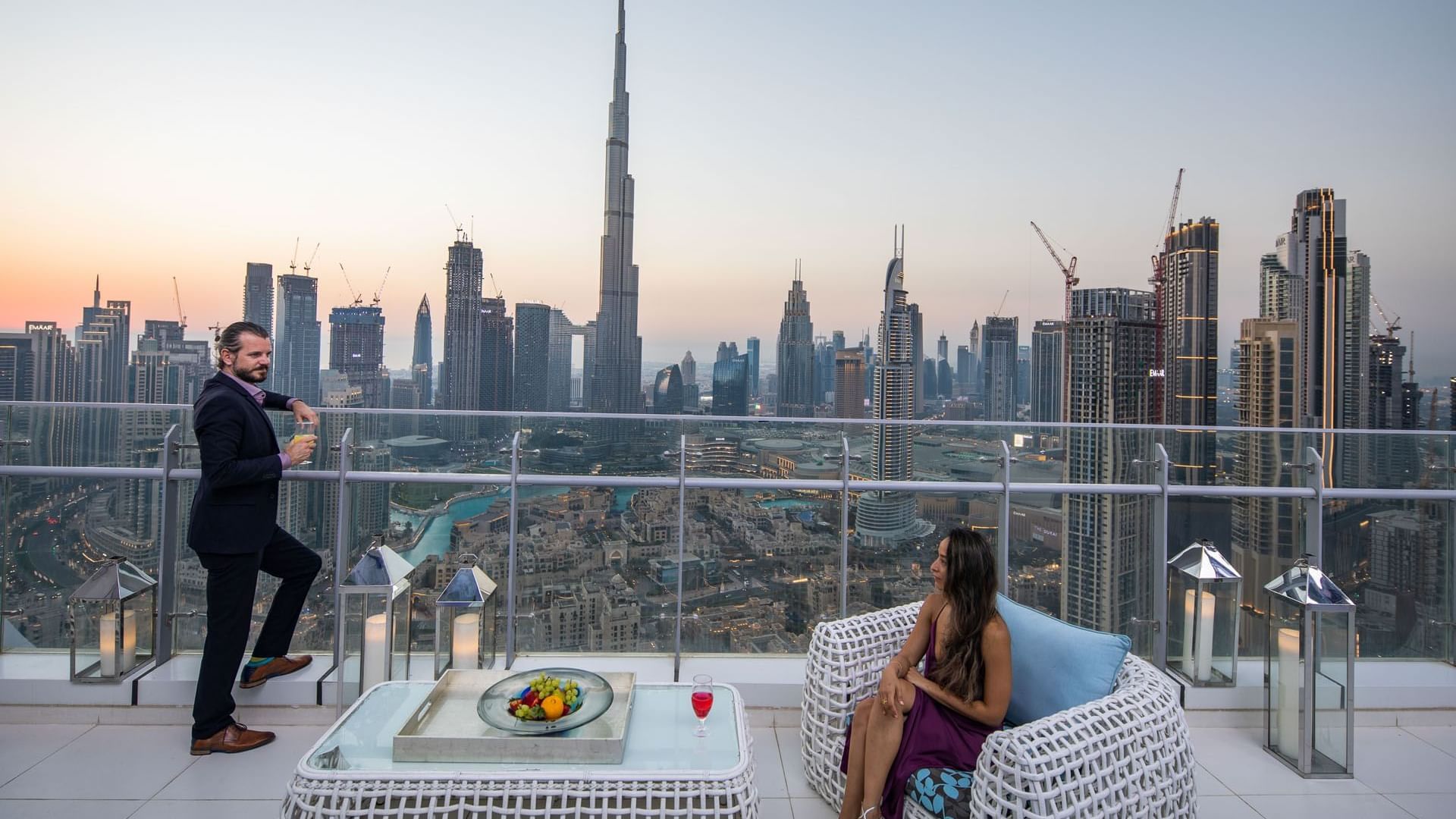 A couple posing on a balcony with overlooking the Burj Khalifa at DAMAC Maison Distinction