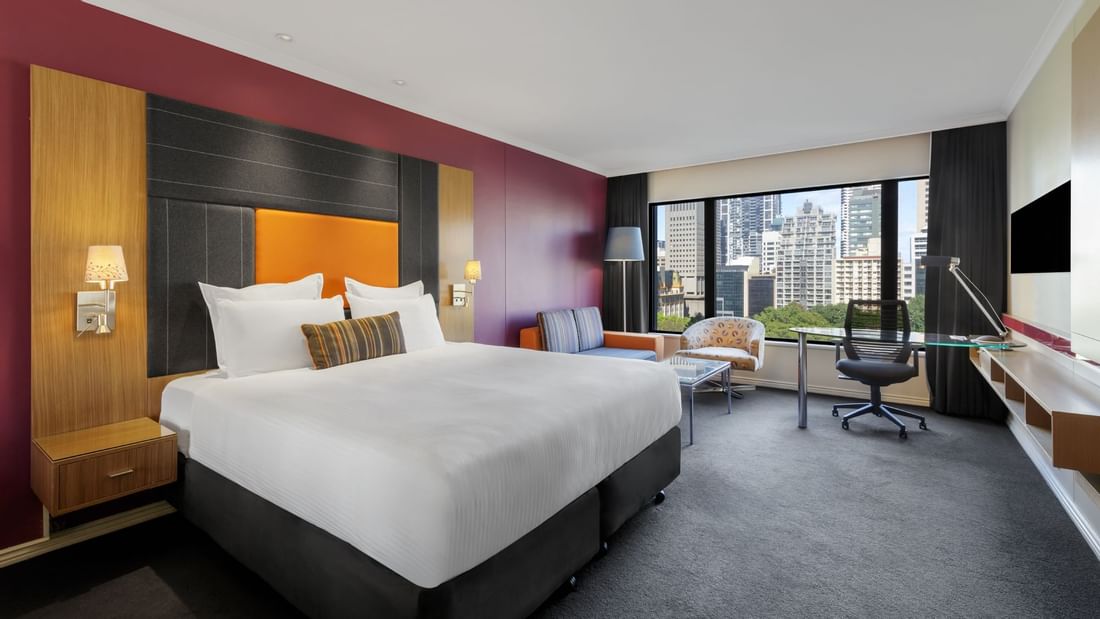 Workspace and lounge area by the bed in Classic Room with carpeted floors at Pullman Sydney Hyde Park