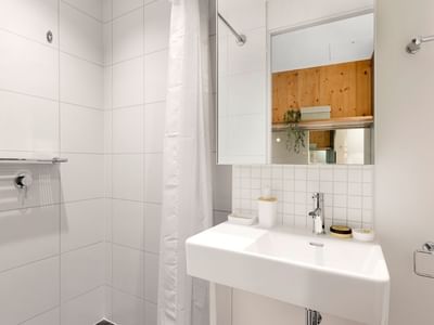 Clean white bathroom with shower, sink, mirror, and towel at La Trobe University - North and South Apartments.