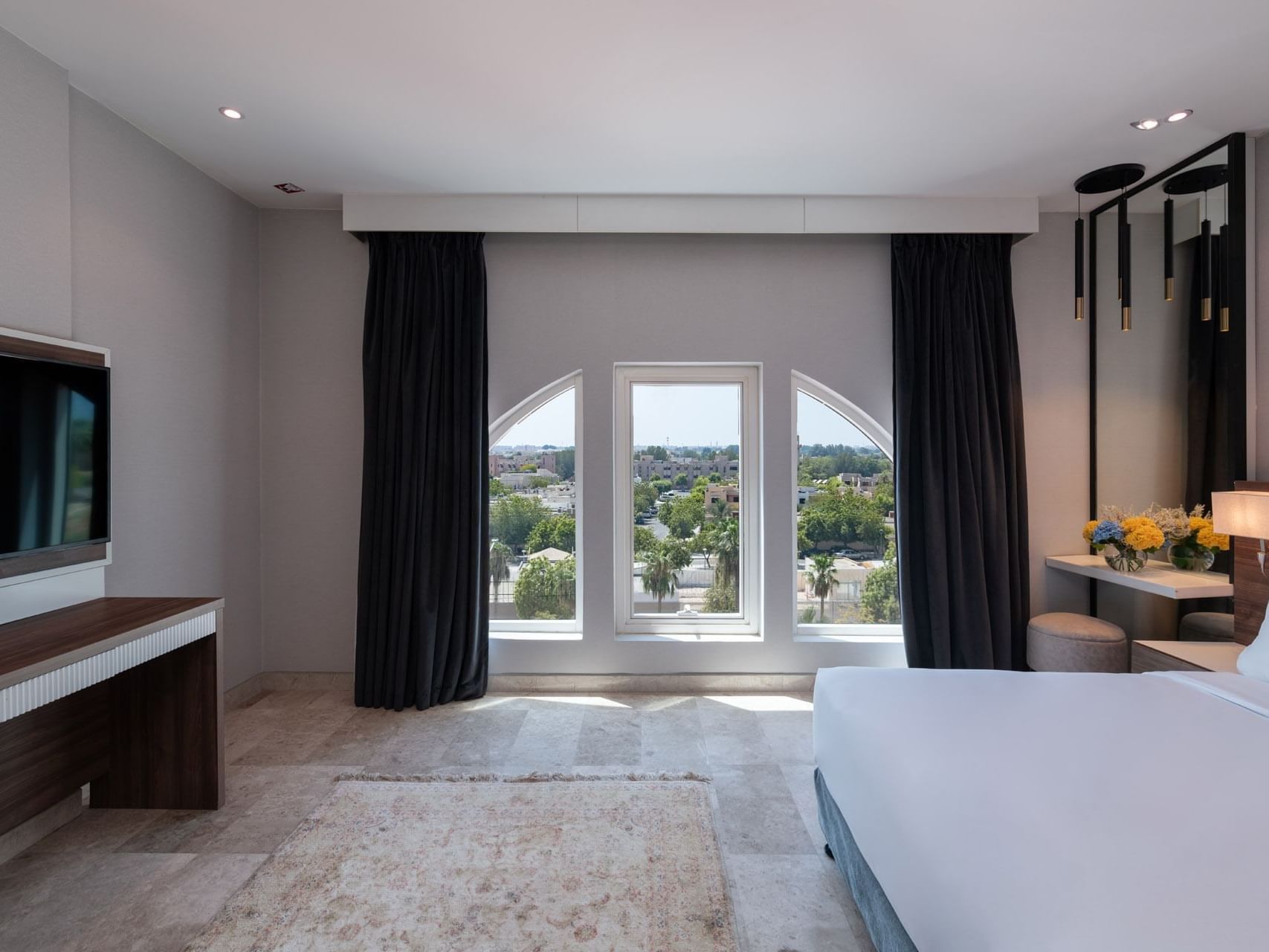 TV-facing bed with a vanity area in Deluxe Room City View at Warwick Hotels & Resorts