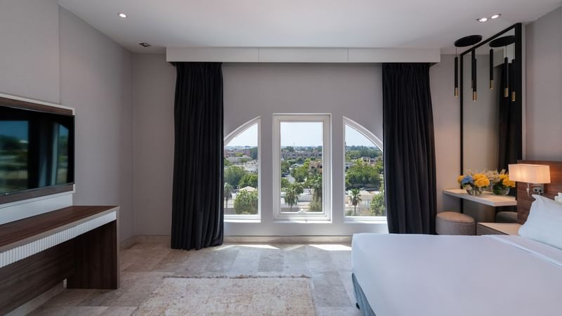 TV-facing bed with a vanity area in Deluxe Room City View at Warwick Hotels & Resorts