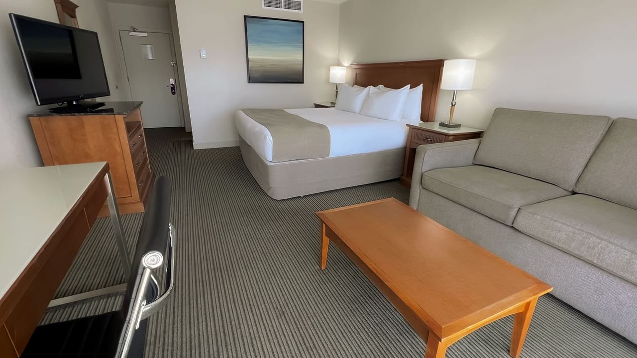 Guest room with king bed, balcony, sofa bed, table, desk, chair