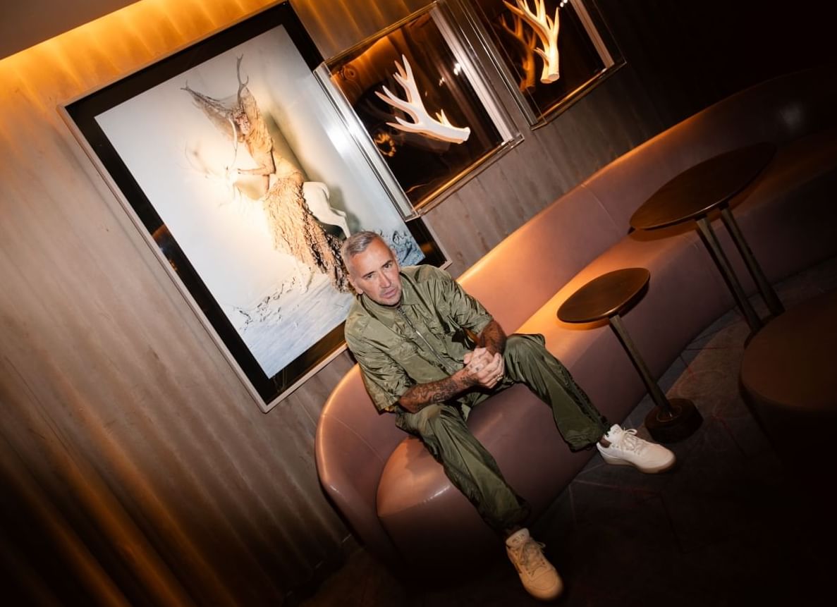 A man posing for a photo in front of a painting at The Londoner Hotel