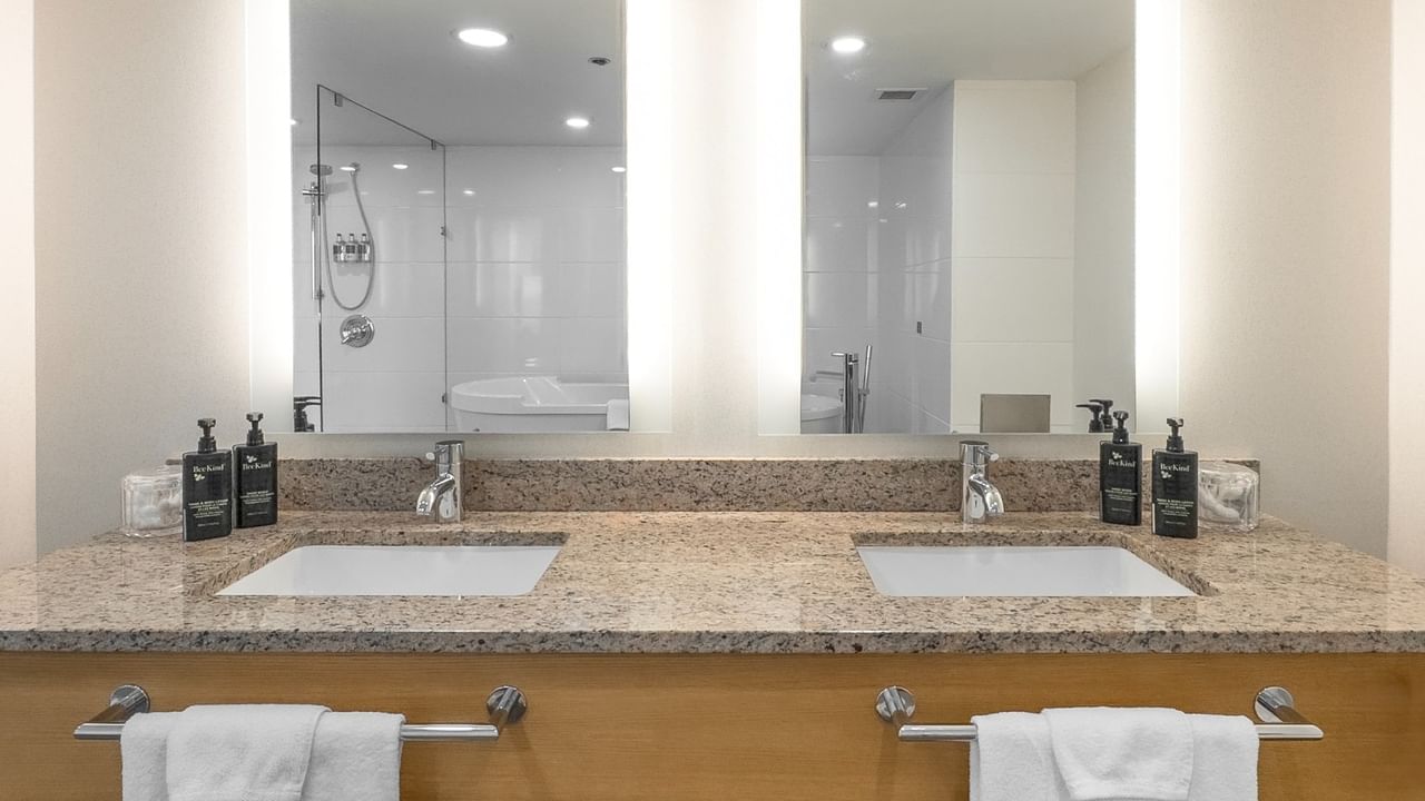 Double sinks with in a bathroom with large mirror.