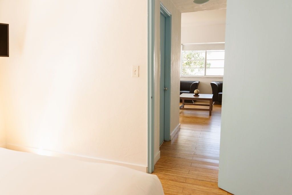 A wide view of a room with a doorway leading to a living area with a sofa and coffee table