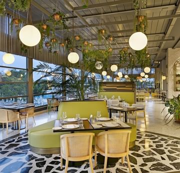 Pascarella, современный ресторан в отеле Titanic Deluxe Lara с зелёными креслами и большими окнами