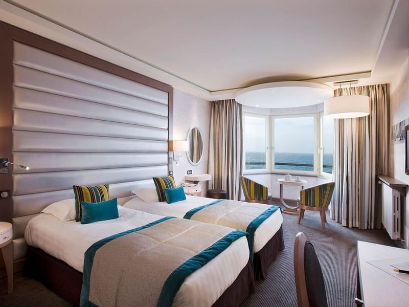 Twin beds & lounge overlooking the sea in Croisiere Salon at Le Grand Hôtel des Thermes