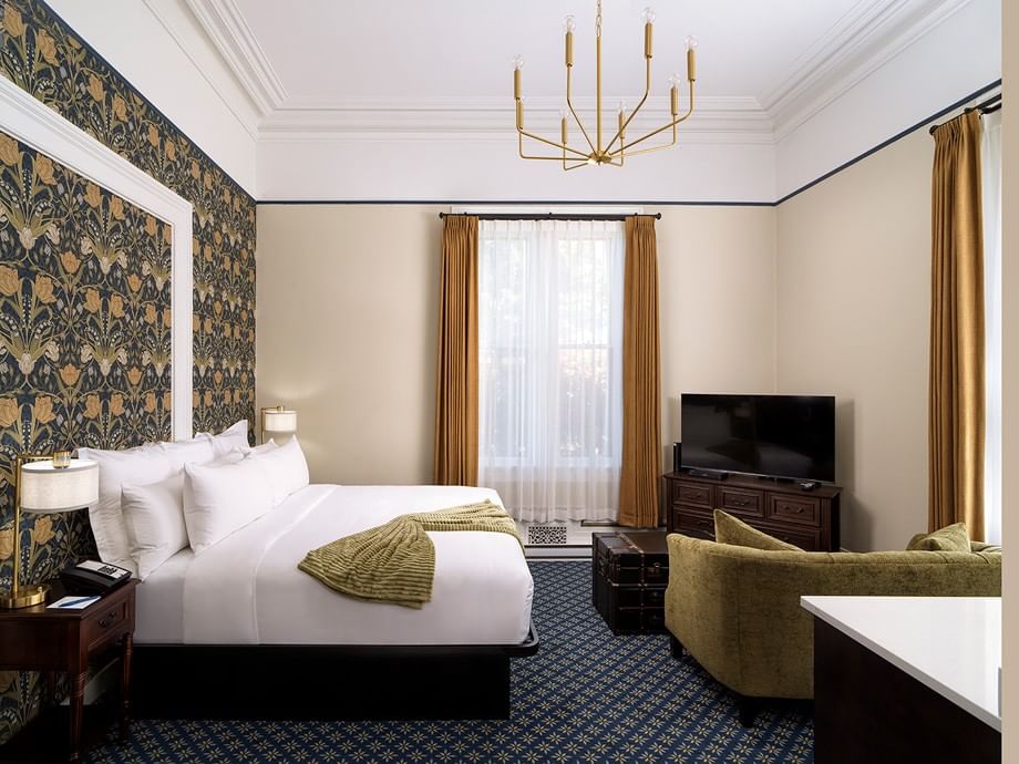Rosewood Room with king bed, floral wallpaper, gold chandelier, and seating area at Belleville House, Pendray Inn Collection, Victoria.