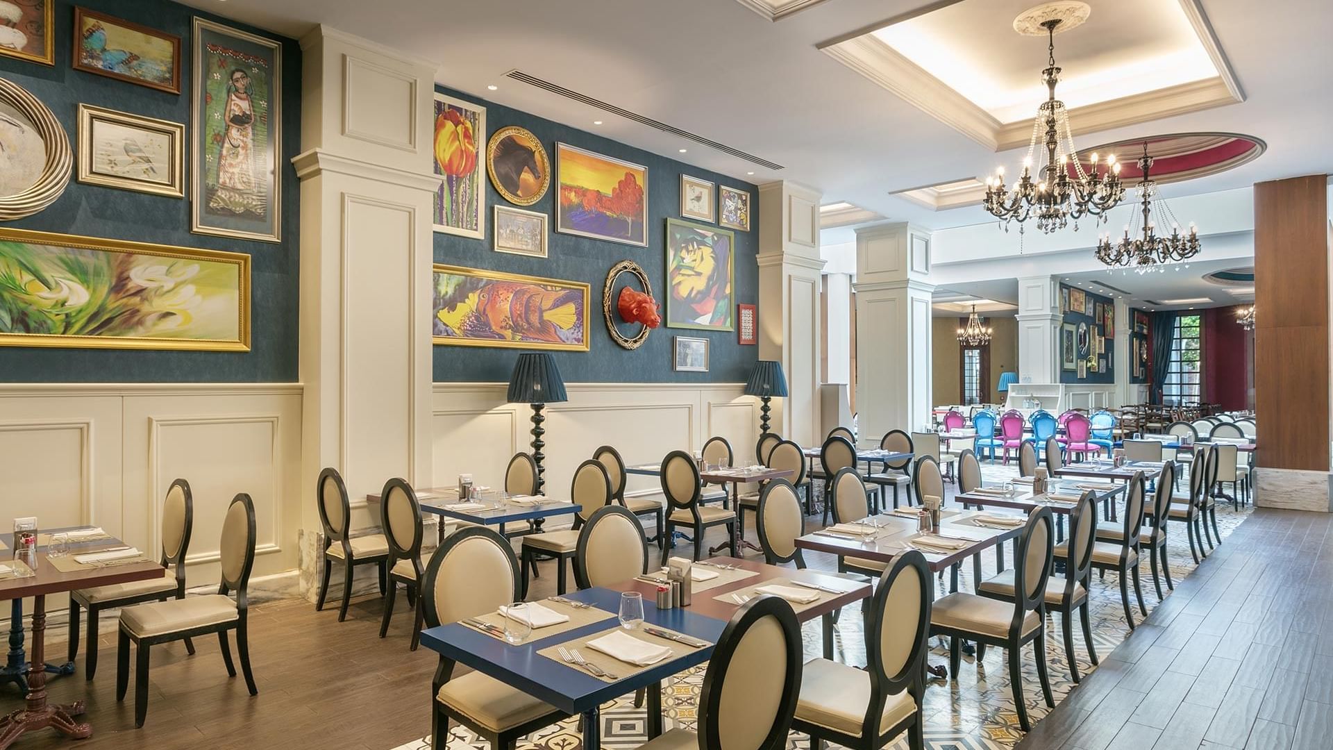 Titanic Deluxe Golf Belek Ana Restoranında, duvar resimleriyle süslü ve ahşap zeminli yemek alanı