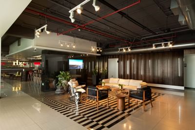 Lobby area with comfy chairs, TV and sofas at D Sabana Hotel, 5 star Hotels in San Jose Costa Rica