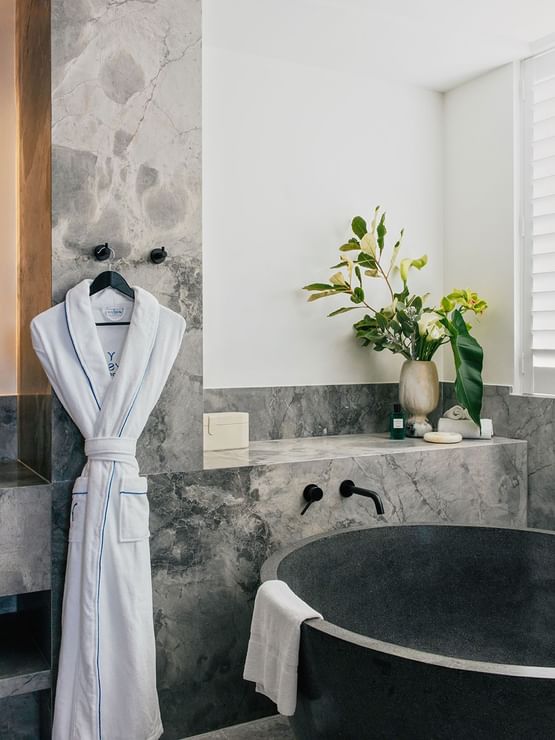 Elysium Two Bedroom Suite at Elysium Manly with a black tub by twin sinks under mirrors, offering cozy Manly accommodation
