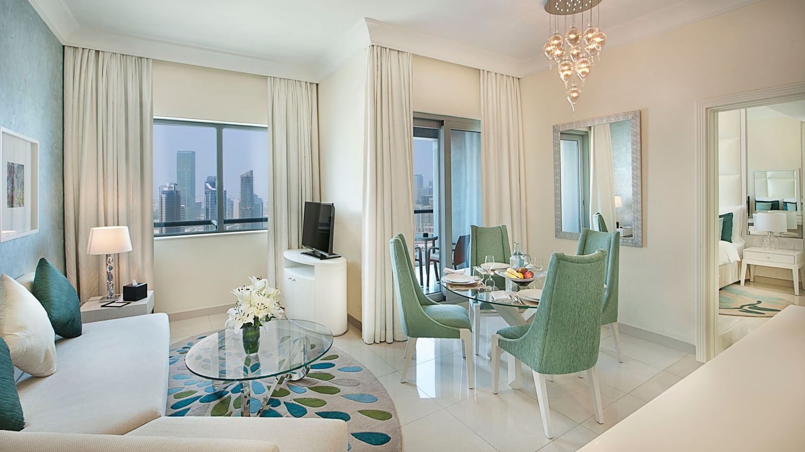 Lounge area with TV and dining table in One Bedroom Suite at DAMAC Maison Dubai Mall Street