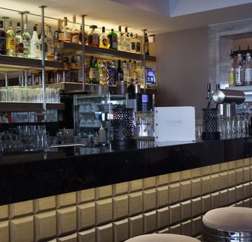 Bar counter with various beverages self in the Lobby Bar at Titanic Comfort Mitte