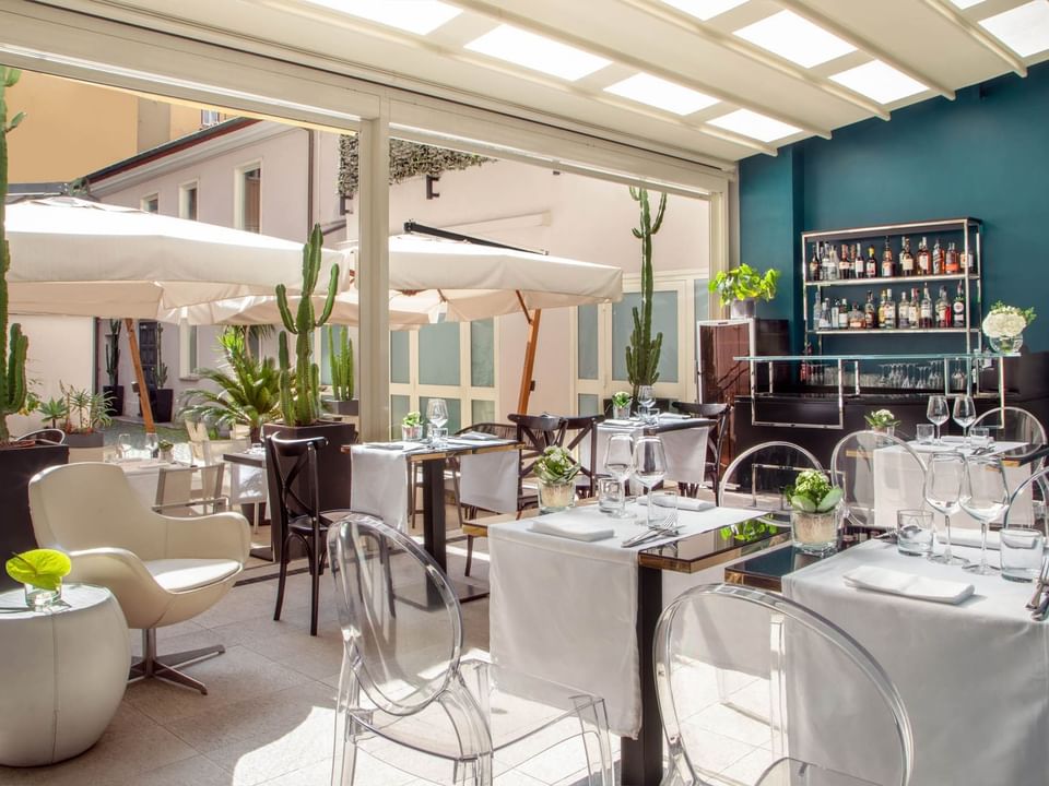 Bright and airy, The Guardian Dehors at The Guardian Hotel with elegant tables, a stocked bar, and a relaxing ambiance