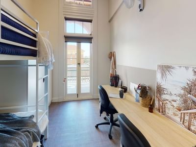 Bunk Room Twin Share with twin bunk beds, two desks and balcony at UniLodge Herston.