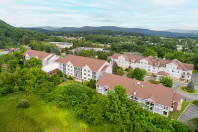 Aerial view of White River Inn and Suites, one of the top White River Junction hotels surrounded by lush greenery & mountains