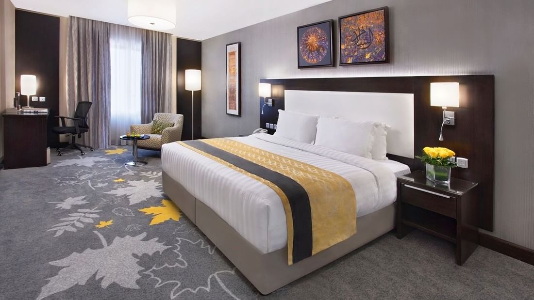 King bed and nightstands in Deluxe Room with carpeted floors at Warwick Hotel Jeddah