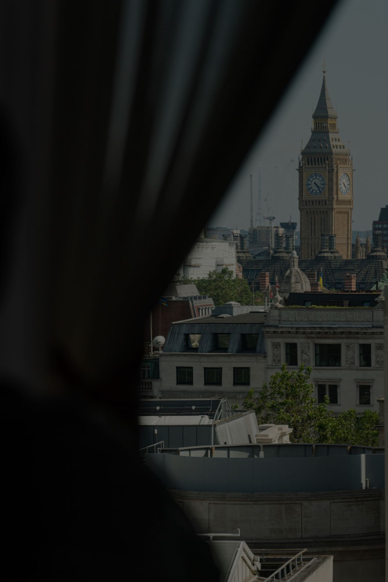 A city skyline view through a window at The Londoner Hotel