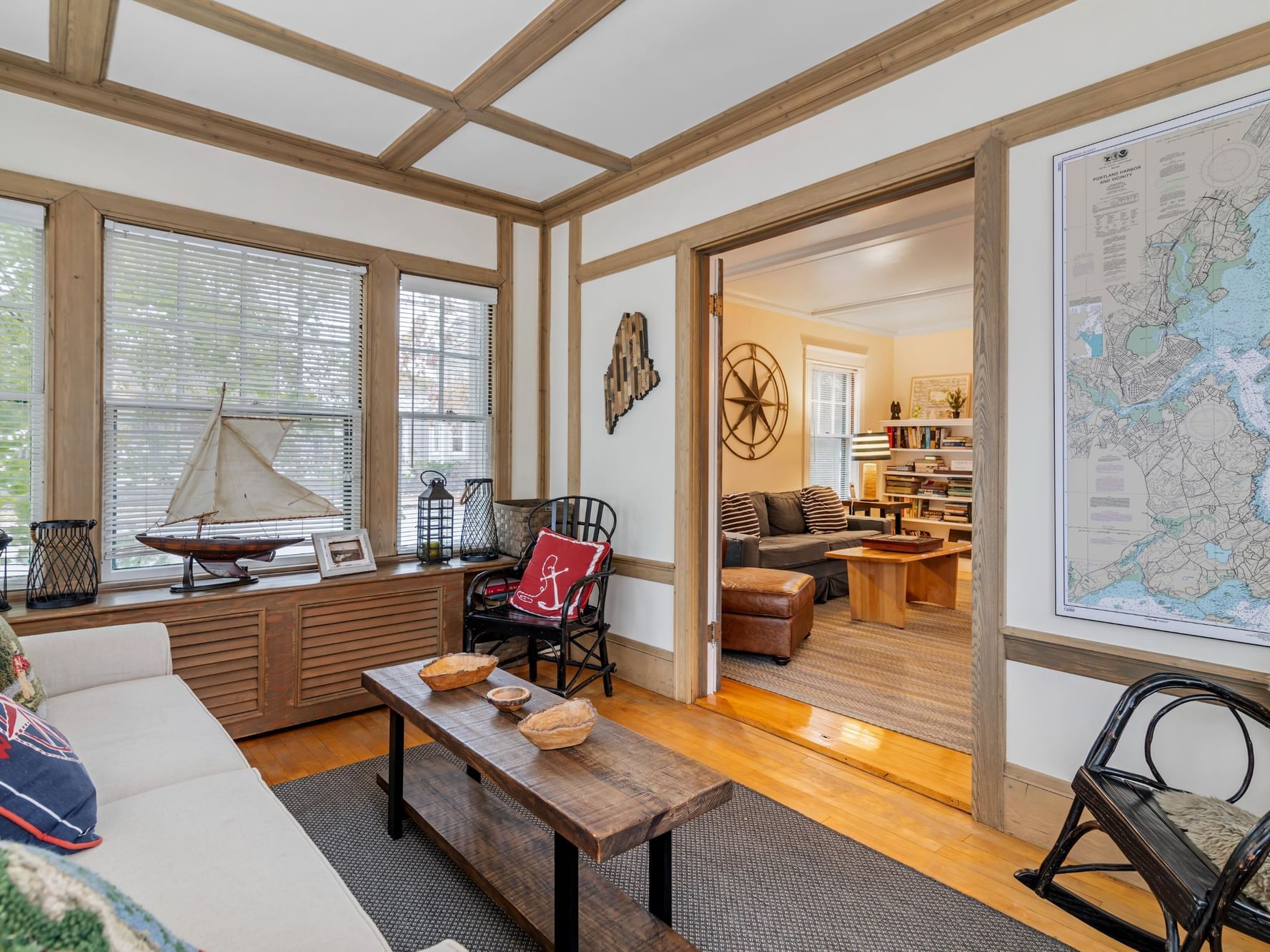 Living area with comfy sofas, coffee table, & Antic wooden interior from States in LL Bean Guest House at Harraseeket Inn