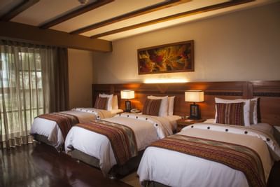 room with three beds and vaulted ceilings