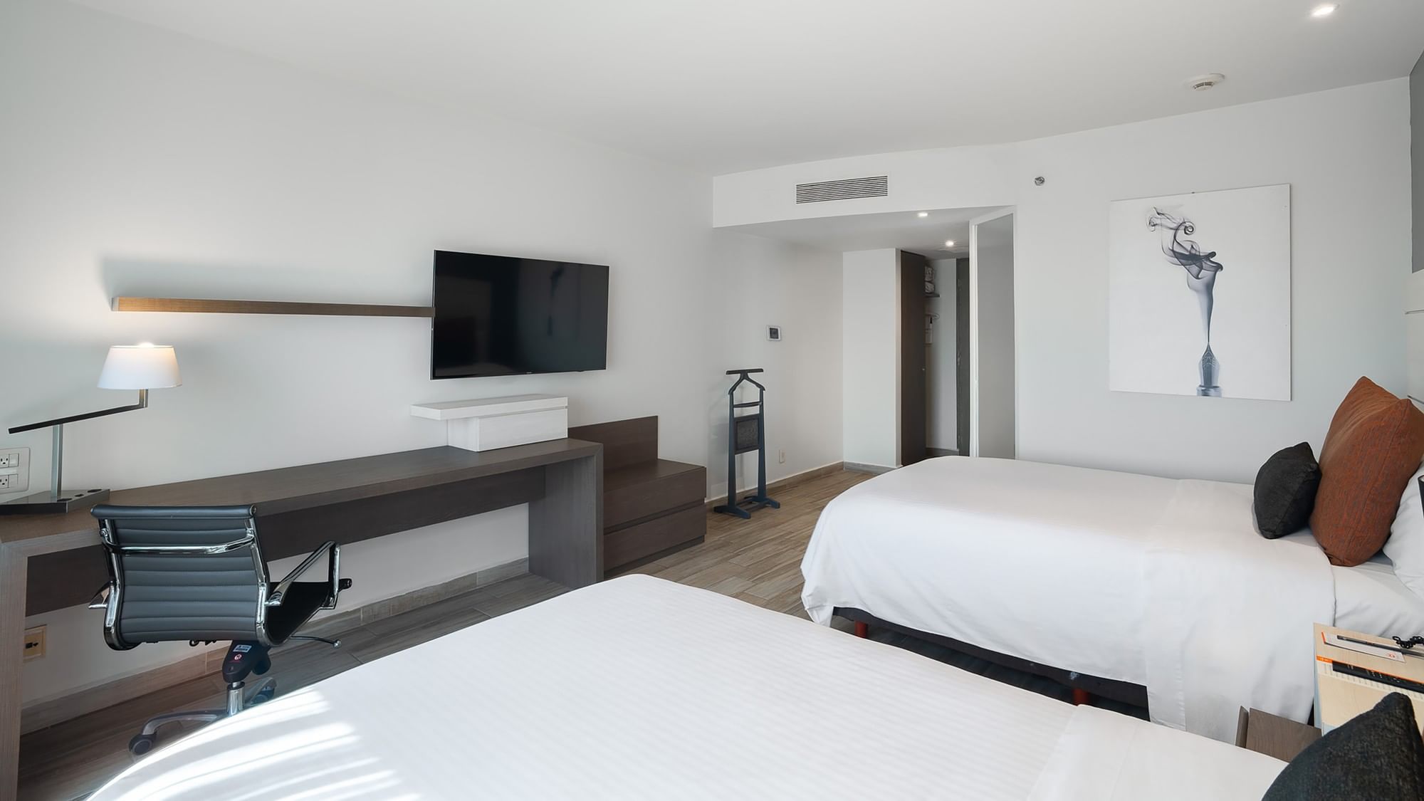 Modern 2 Double Deluxe room with two beds, desk, TV, and artwork at Real Inn Perinorte Tlalnepantla.